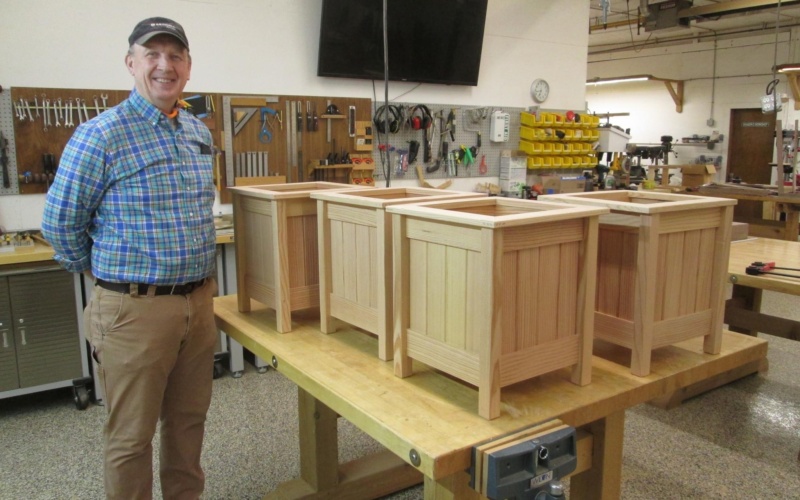 Dean Clasen and planter stands he built for the recent Saint Mary's Gala.